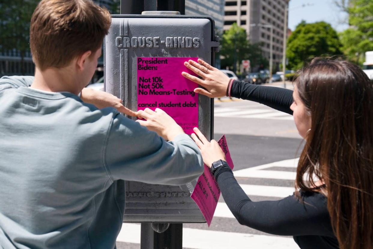 George Washington University students put up posters near the White House promoting student loan debt forgiveness