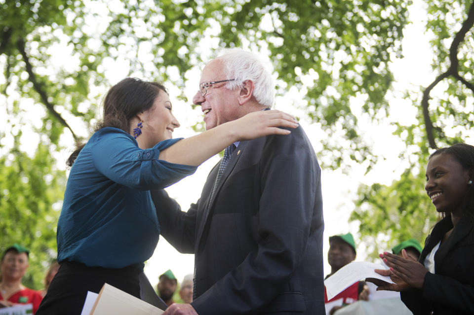 UNITED STATES - MAY 19: Sen. Bernie Sanders, I-Vt., hugs Alexandra Flores-Quilty, 23, of Oregon, who has $50,000 in student debt, during news conference at the Senate swamp on legislation "to eliminate undergraduate tuition at public colleges and universities and to expand work-study programs," May 19, 2015. (Photo By Tom Williams/CQ Roll Call)