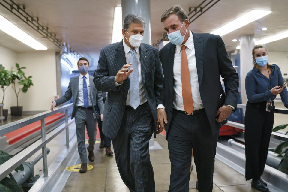 Sen. Joe Manchin, D-W.Va., left, and Sen. Mark Warner, D-Va., key moderates, return to the Senate chamber for a vote at the Capitol in Washington, Thursday, Sept. 23, 2021. Senate Majority Leader Chuck Schumer and House Speaker Nancy Pelosi say they and the White House have agreed to a "framework" to pay for their emerging $3.5 trillion social and environment bill. (AP Photo/J. Scott Applewhite)