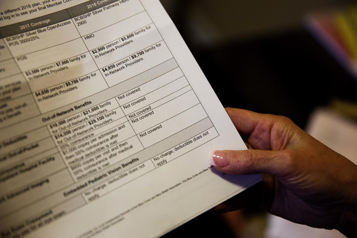 A woman looks over her health insurance benefit comparison chart: AP Photo/David Goldman