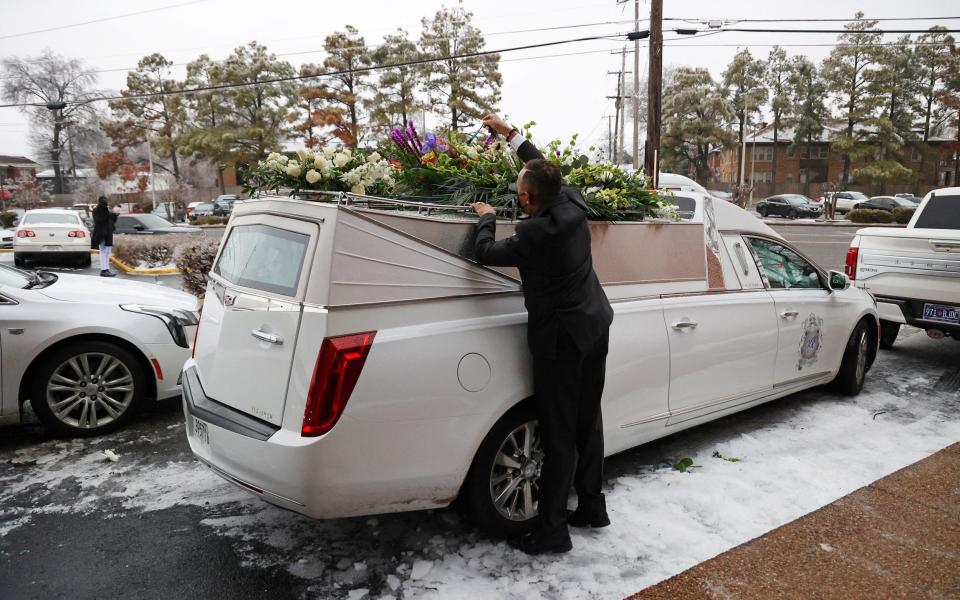 Flowers are secured on a hearse after the memorial service - Reuters