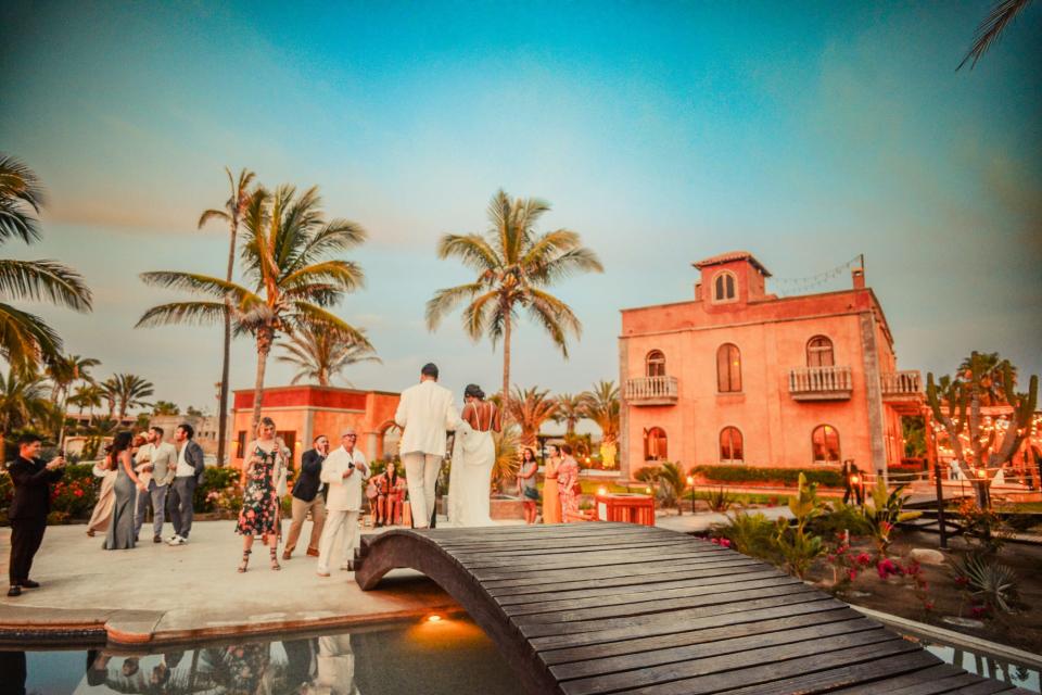 A couple walks into their wedding reception at a beach hotel.