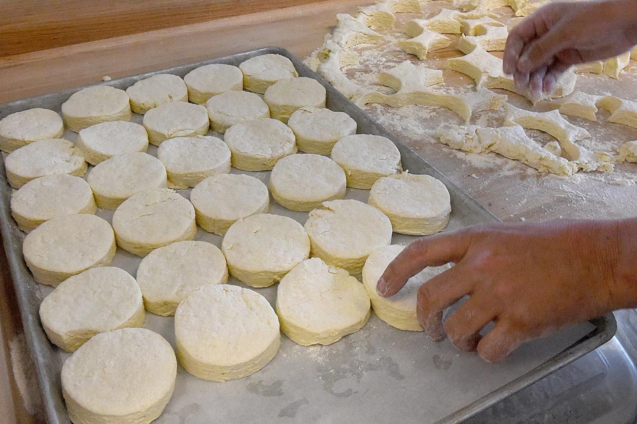 Ozark Mountain Biscuit & Bar owner Bryan Maness places made-from-scratch buttermilk biscuits on a pan to prepare them for the oven.