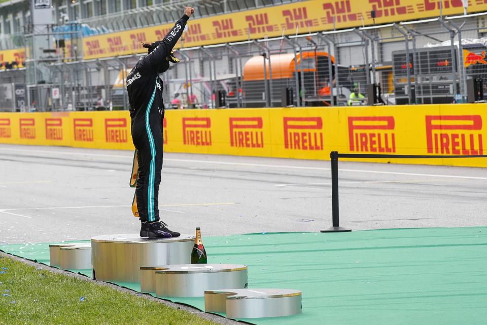 Mercedes' British driver Lewis Hamilton raises a fist on the podium after winning the Formula One Styrian Grand Prix race on July 12, 2020 in Spielberg, Austria. (Photo by LEONHARD FOEGER / POOL / AFP) (Photo by LEONHARD FOEGER/POOL/AFP via Getty Images)