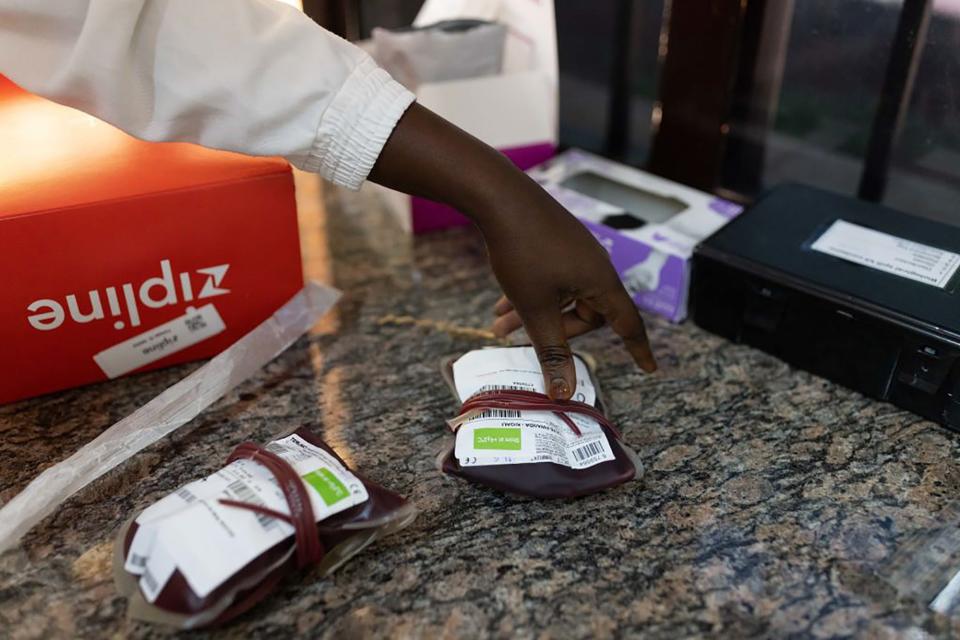 A nurse processes blood, delivered by a drone, at a local hospital on June 30, 2022, in Rwinkwavu, Rwanda. Zipline, a California-based company that creates drone-based delivery systems, has run projects in Rwanda and Ghana for several years and recently started operations in Nigeria, where it focuses on areas that are difficult to navigate by road.