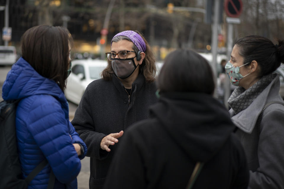 Victoria Martinez, 44, speaks with other mothers at the gates of her daughters' school, one of the few public spaces where she dares to socialize, in Barcelona, Spain, Wednesday, Feb. 10, 2021. By May this year, barring any surprises, Martinez will complete a change of both gender and identity at a civil registry in Barcelona, finally closing a patience-wearing chapter that has been stretched during the pandemic. The process, in her own words, has also been “humiliating.” (AP Photo/Emilio Morenatti)