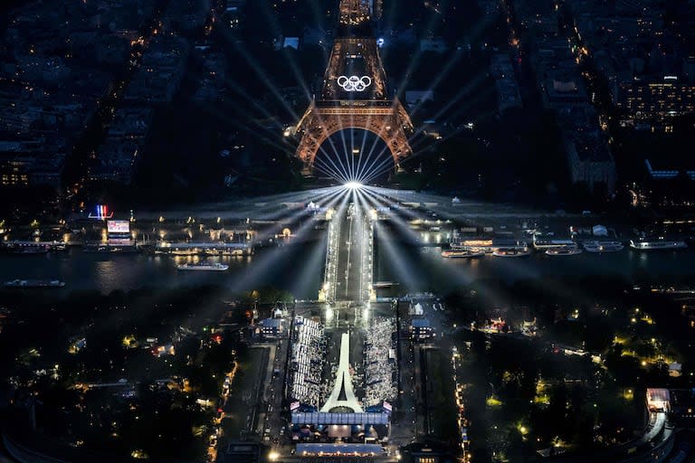 Una fotografía tomada desde un helicóptero el 26 de julio de 2024 muestra una vista aérea de la Torre Eiffel y los anillos olímpicos iluminados durante la ceremonia de apertura de los Juegos Olímpicos