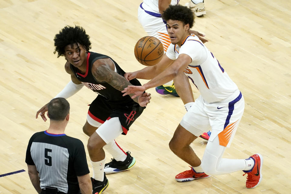 Houston Rockets guard Kevin Porter Jr. and Phoenix Suns forward Cameron Johnson, right, battle for a loose ball during the first half of an NBA basketball game, Monday, April 12, 2021, in Phoenix. (AP Photo/Matt York)