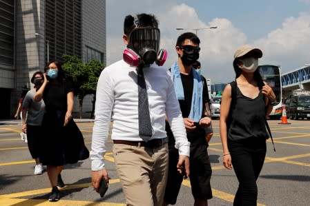 Anti-government office workers wearing masks attend a lunch time protest, after local media reported on an expected ban on face masks under emergency law, at Central, in Hong Kong