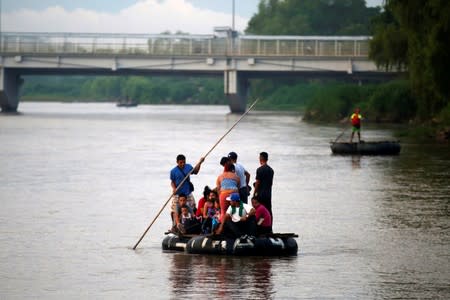 Migrants cross the Suchiate river on a raft from Tecun Uman, in Guatemala, to Ciudad Hidalgo, as seen from Ciudad Hidalgo