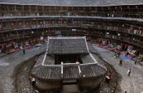 Los visitantes caminan <b>dentro de una Fujian Tulou de 700 años</b>, en el condado de Nanjing en China. Este tipo de construcciones han servido al pueblo hakka para defenderse de sus enemigos desde el siglo XI. (REUTERS/Stringer).