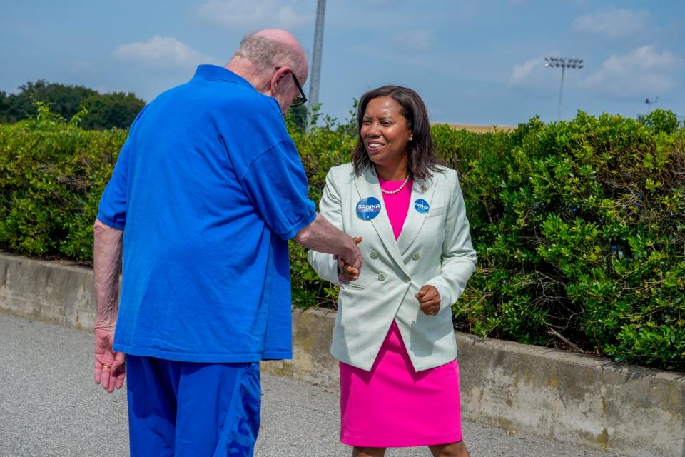 Sabina Matos greets voters at Barrington High School polling place.