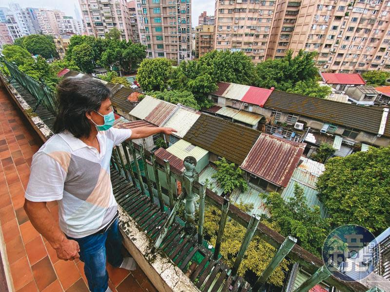 王姓住戶站在屋齡49年的老公寓，指著眼前即將都更的忠誠新村，希望北市府能將他們納入都更範圍。