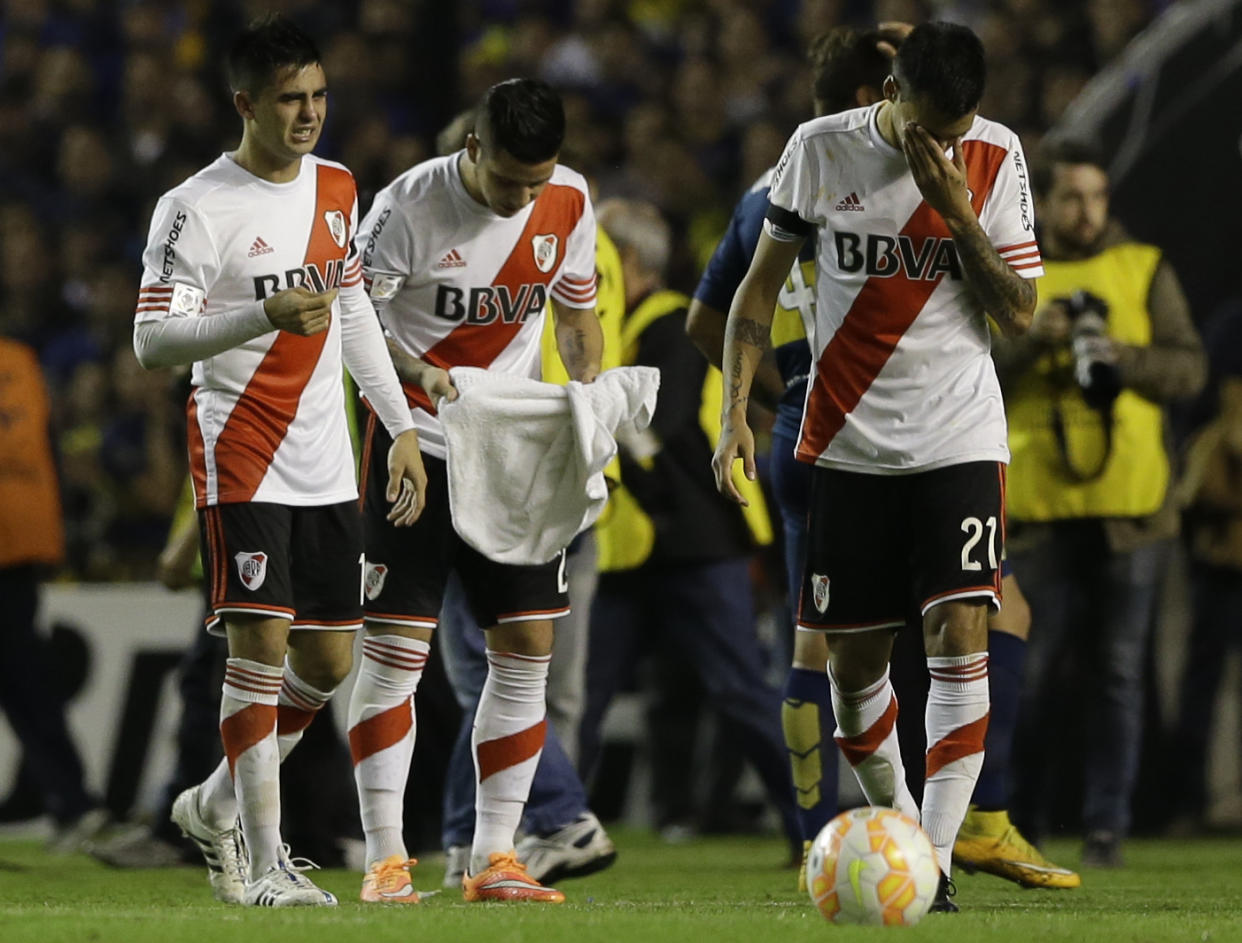 Los jugadores de River Plate sufren con los efectos de un gas con el que fueron rociados durante el partido contra Boca Juniors por la Copa Libertadores, el jueves 14 de mayo de 2015. (AP Foto/Natacha Pisarenko)