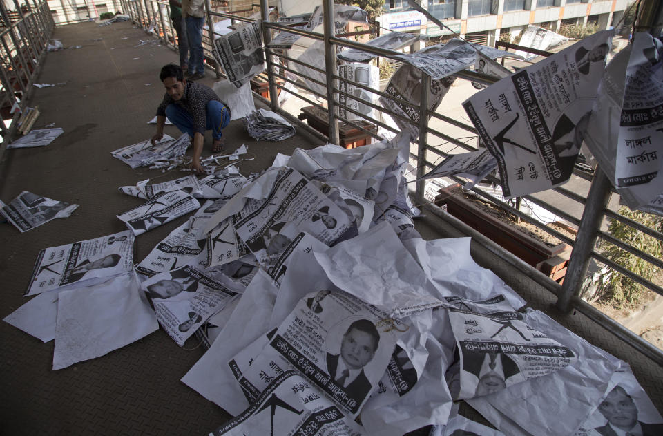 A Bangladeshi man collects election posters in Dhaka, Bangladesh, Monday, Dec. 31, 2018. Bangladesh's ruling alliance won virtually every parliamentary seat in the country's general election, according to official results released Monday, giving Prime Minister Sheikh Hasina a third straight term despite allegations of intimidation and the opposition disputing the outcome. (AP Photo/Anupam Nath)