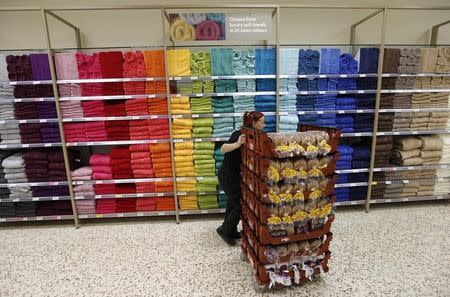 A bakery employee pushes a cart with loaves of bread past a towel display at a Tesco Extra supermarket in Watford, north of London August 8, 2013. REUTERS/Suzanne Plunkett