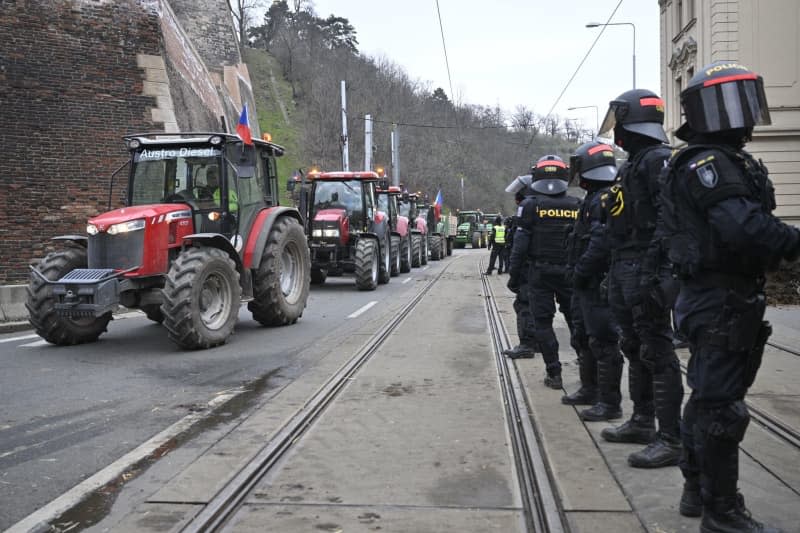 Police officers stand guard where farmers with their tractors protest against EU agricultural policies and the failed negotiations with the Czech government to further support farmers. Šimánek Vít/CTK/dpa