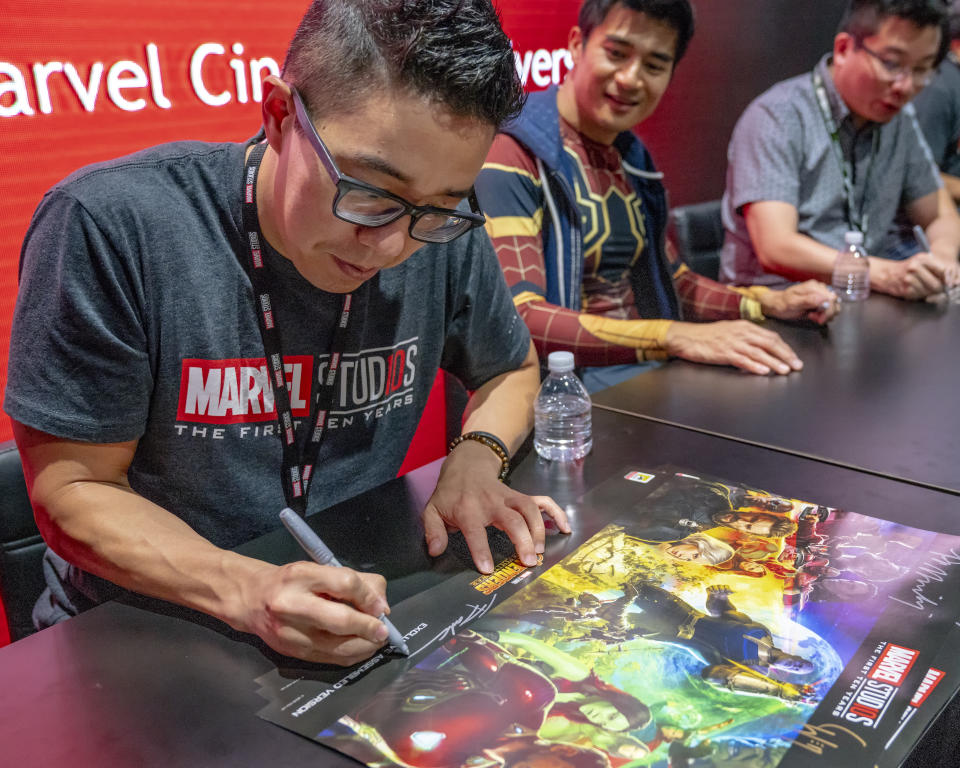 Andy Park, Supervisor of the Marvel Studios Visual Development Team signs Avengers: Infinity War posters at the Marvel Studios booth on day two of Comic-Con International on Friday, July 20, 2018 in San Diego, CA. (Photo by Christy Radecic/Invision/AP)