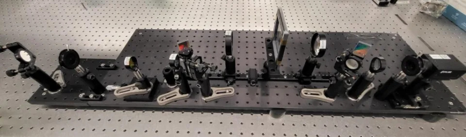 Components of a research-grade camera spread in a row on a scientific table.