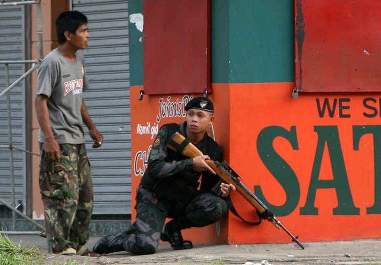 A police sniper gets into position to confront MNLF rebels in Zamboanga City in the Philippines on September 9, 2013