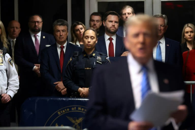 Senator JD Vance (center, red tie), Senator Tommy Tuberville (back right, blue tie) and Eric Trump (center back) look on as former US president Donald Trump speaks to reporters at his trial for allegedly covering up hush money payments (Spencer Platt)