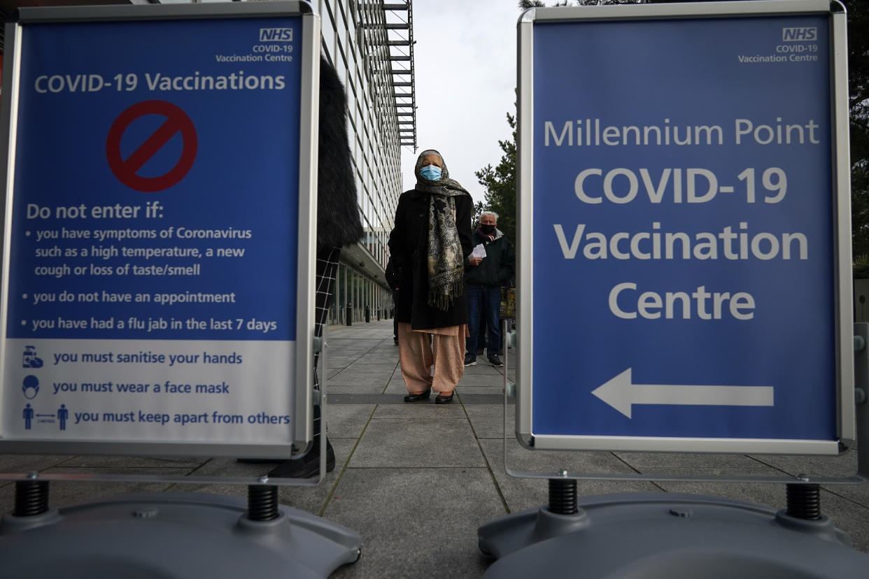 BIRMINGHAM, ENGLAND - JANUARY 11: People queue outside the mass NHS Covid-19 vaccine centre that has been set up at the Millennium Point centre in Birmingham on January 11, 2021 in Birmingham, England. The location is one of several mass vaccination centres in England to open to the public this week. The UK aims to vaccinate 15 million people by mid-February. (Photo by Christopher Furlong/Getty Images)