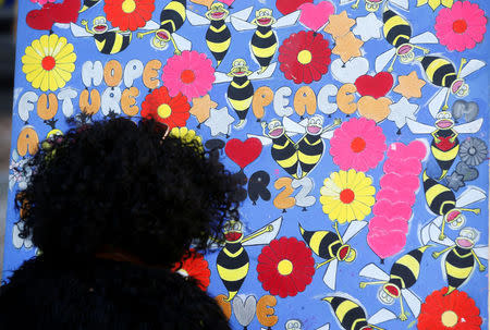 A woman looks at a tribute in St Anne's Square on the first anniversary of the Manchester Arena bombing, in Manchester, Britain, May 22, 2018. REUTERS/Andrew Yates