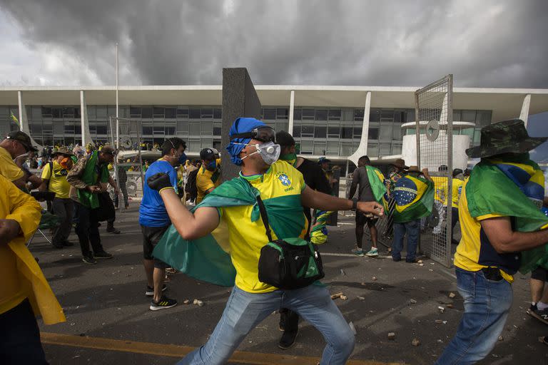 BRASILIA, BRAZIL - JANUARY 08: Supporters of former President Jair Bolsonaro clash with security forces as they break into Planalto Palace and raid Supreme Court in Brasilia, Brazil, 08 January 2023. Groups shouting slogans demanding intervention from the army broke through the police barrier and entered the Congress building, according to local media. Police intervened with tear gas to disperse pro-Bolsonaro protesters. Bolsonaro supporters managed to invade and ransack the National Congress, Planalto Palace, or President's office, and the Supreme Federal Court. (Photo by Joedson Alves/Anadolu Agency via Getty Images)