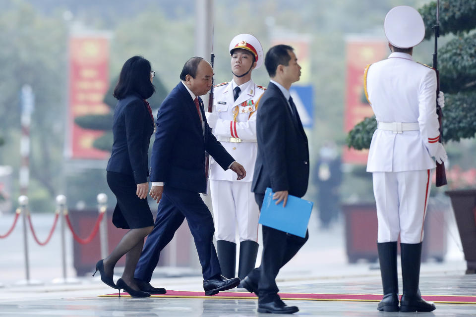 Vietnam Prime Minister Nguyen Xuan Phuc, second left, arrives at the national convention center to attend the 13th Communist Party Congress in Hanoi, Vietnam Tuesday, Jan. 26, 2021. Vietnam's ruling Communist Party has begun a crucial weeklong meeting in the capital Hanoi to set the nation's path for the next five years and appoint the country's top leaders. (AP Photo/Minh Hoang)