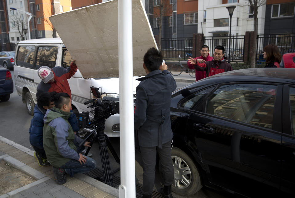 In this Dec. 4, 2013 photo, Chinese director Sun Zhendong, second from right, directs his crew as they prepare to film the “Mr. Ball” microfilm near a residential buildings in Changping, on the outskirts of Beijing. Microfilms, uploaded to Chinese YouTube-style and video-streaming sites, offer themes and subjects you won’t come across in China’s strictly censored cinemas. And thanks to video-capturing smartphones and basic editing software available on laptops, anyone can be a director these days. (AP Photo/Andy Wong)