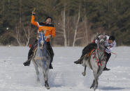 A rider throws the javelin during a game of Cirit, a traditional Turkish equestrian sport that dates back to the martial horsemen who spearheaded the historical conquests of central Asia's Turkic tribes, between the Comrades and the Experts local sporting clubs, in Erzurum, eastern Turkey, Friday, March 5, 2021. The game that was developed more than a 1,000 years ago, revolves around a rider trying to spear his or her opponent with a "javelin" - these days, a rubber-tipped, 100 centimeter (40 inch) length of wood. A rider from each opposing team, which can number up to a dozen players, face each other, alternately acting as the thrower and the rider being chased. Cirit was popular within the Ottoman empire, before it was banned as in the early 19th century. However, its popularity returned as is now one of many traditional sports encouraged by the government and tournaments are often arranged during festivals or to celebrate weddings. (AP Photo/Kenan Asyali)