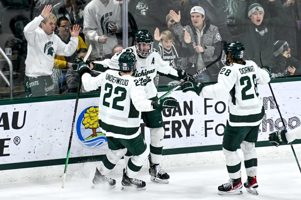 Michigan State's Cole Krygier, center, celebrates his goal with teammates Michael Underwood, left, and Karsen Dorwart during the first period in the game against Michigan on Friday, Dec. 9, 2022, at Munn Arena in East Lansing.