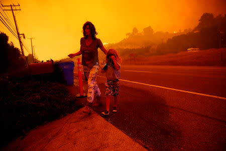 Gabi y Jonah Frank caminan en la Autopista del Pacífico, luego de que el incendio Woosley amenazó su hogar en Malibú. 9 de noviembre de 2018. REUTERS/Eric Thayer