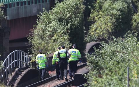 Police officer comb the scene after three men died on the railway - Credit: Yui Mok/PA