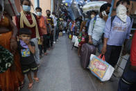 Indian passengers queue up to test for COVID-19 at a facility erected at a railway station to screen people coming from outside the city, in Ahmedabad, India, Friday, Sept. 18, 2020. India's coronavirus cases jumped by another 96,424 in the past 24 hours, showing little sign of leveling. India is expected to have the highest number of confirmed cases within weeks, surpassing the United States, where more than 6.67 million people have been infected. (AP Photo/Ajit Solanki)