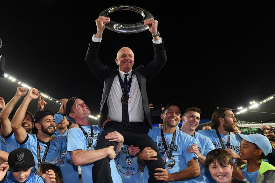 Arnold holds the A-League trophy as Sydney FC coach in 2017.