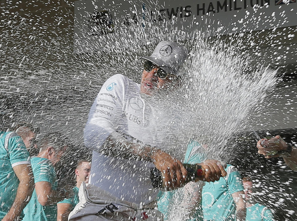 Lewis Hamilton celebrates with a team members