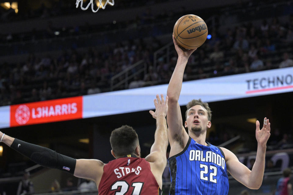 Orlando Magic forward Franz Wagner (22) goes up to shoot as Miami Heat guard Max Strus (31) defends during the first half of an NBA basketball game, Saturday, March 11, 2023, in Orlando, Fla. (AP Photo/Phelan M. Ebenhack)