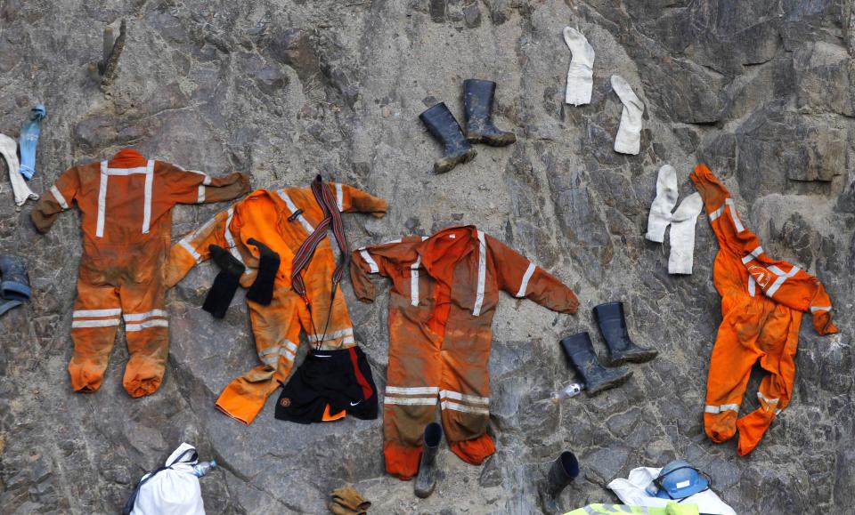 Clothing used by miners dry on a rock wall outside the entrance of the Cabeza de Negro gold-and-copper mine where some miners are trapped in Yauca del Rosario, Peru, Tuesday April 10, 2012. Authorities say nine miners trapped inside the wildcat mine since April 5 are being supplied with sports drinks, soup and food while emergency responders work to free them.  (AP Photo/Martin Mejia)