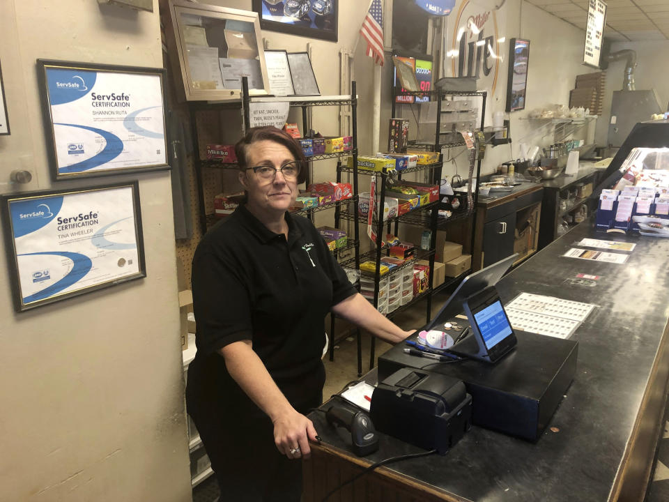 Tina Wheeler, manager of Dan and Vi's pizza poses for a photo, Thursday, Oct. 10, 2019 in Detroit. Dan and Vi’s pizza deli, one of the few eateries near the Detroit-Hamtramck General Motors plant, says sales have been down, though Wednesday’s noontime crowd snaked around the small shop nearly to the door. “We’re definitely noticing a difference in sales, but we’re gonna be OK,” said manager Tina Wheeler. “We’ve been in the neighborhood 56 years. We’re not going anywhere.” (AP Photo/Corey Williams)