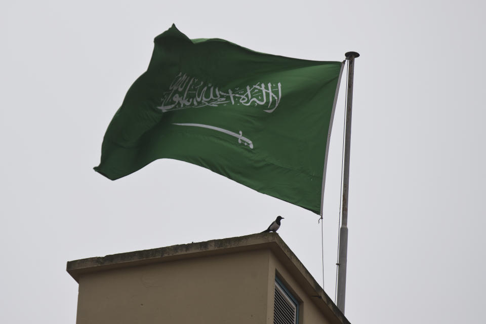 A bird sits by a Saudi Arabia's flag on the roof top of Saudi Arabia's consulate in Istanbul, Sunday, Oct. 14, 2018. Writer Jamal Khashoggi vanished after he walked into the consulate on Oct. 2. (AP Photo/Petros Giannakouris)