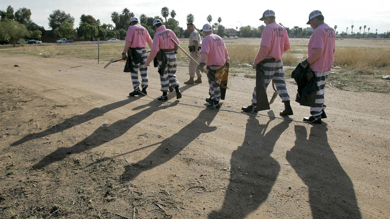 Members of the Maricopa County DUI chain gang are escorted to their assignment in Phoenix