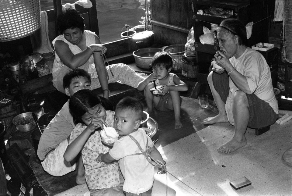 A family eating a meal aboard a fishing boat at Aberdeen Harbor.