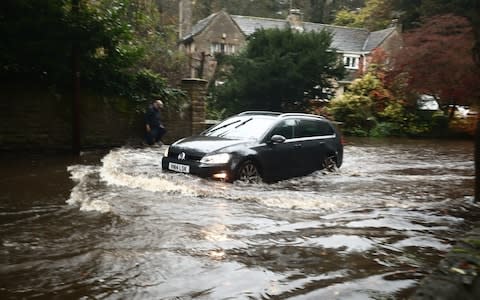 A car passing through a flooded road in Whirlow, Sheffield - Credit: PA