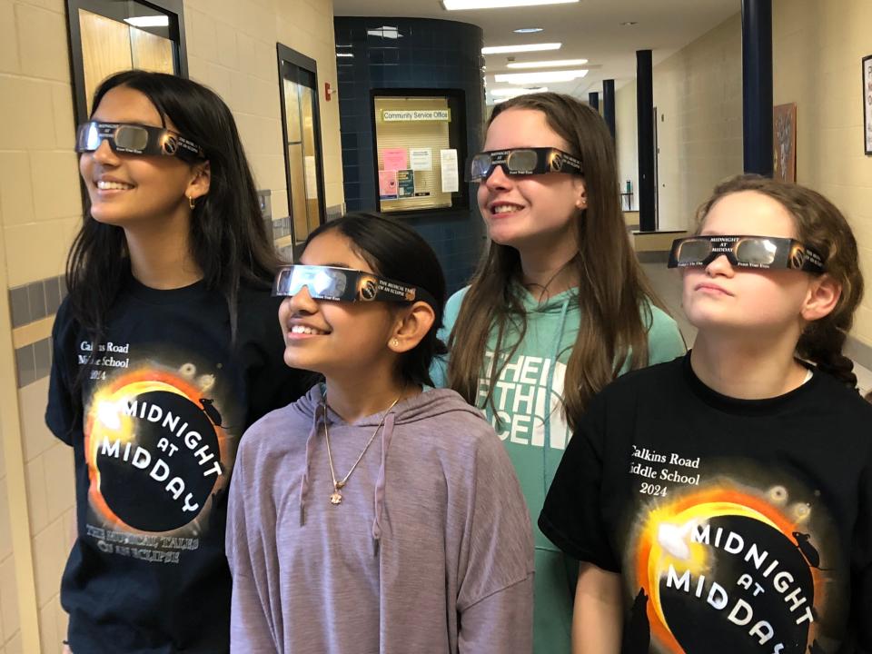 From left to right, cast and orchestra members Misha Saxena, Abiah Joseph, Rebecca Refermat and Addison Bryant wear Midnight at Midday eclipse glasses.   The Calkins Road Drama Club is selling these ISO certified glasses for $3 before performances and during intermission.