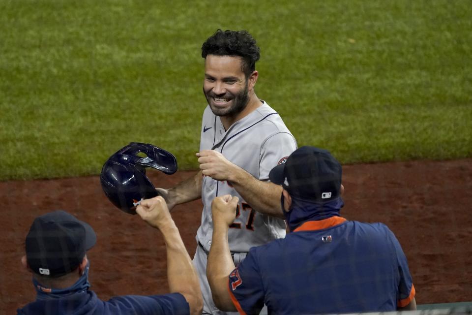 Houston Astros' Jose Altuve celebrates with staff in the dugout after scoring on a Yuli Gurriel single in the eighth inning of a baseball game against the Texas Rangers in Arlington, Texas, Friday, Sept. 25, 2020. (AP Photo/Tony Gutierrez)