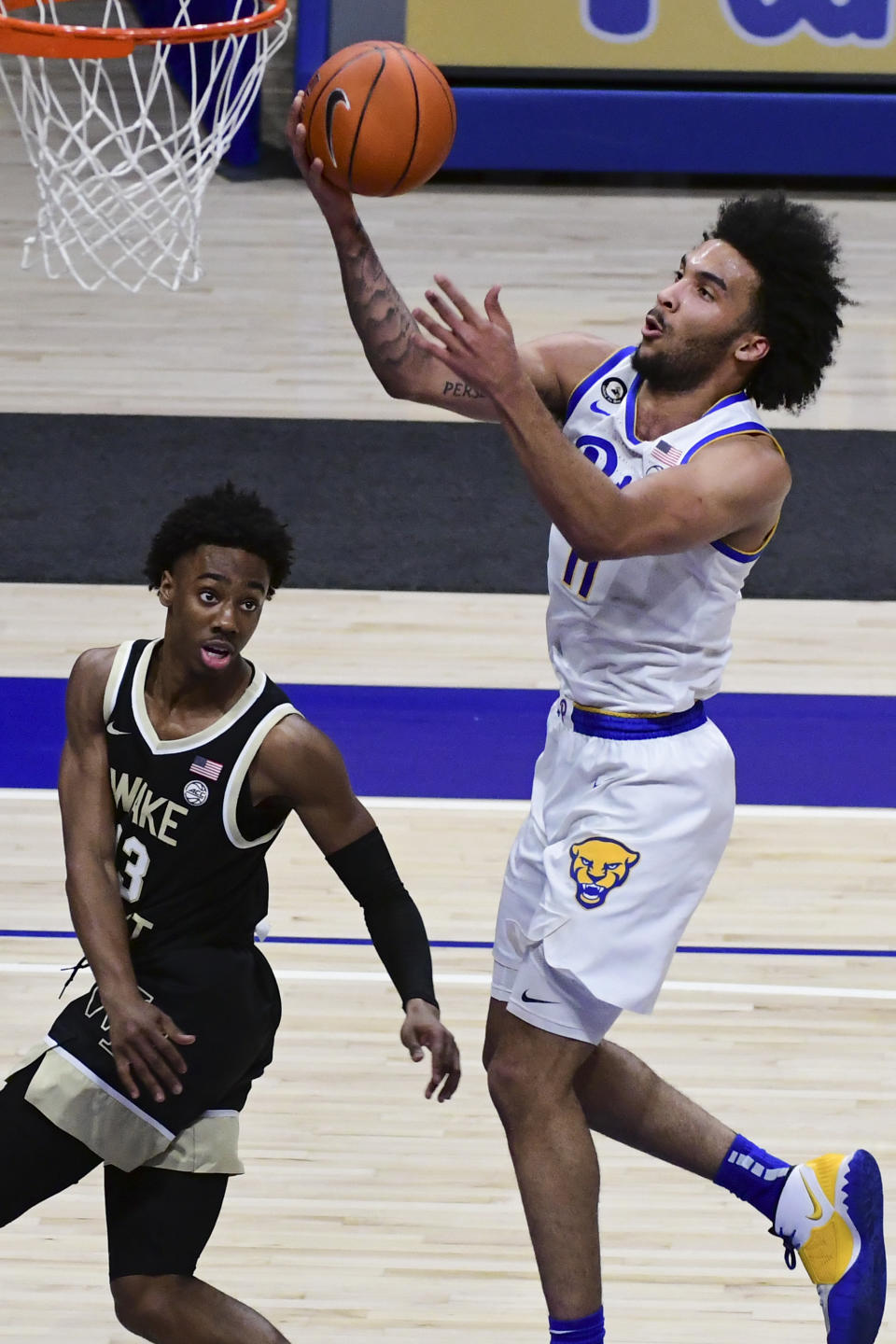 Pittsburgh forward Justin Champagnie drives to the basket against Wake Forest guard Quadry Adams during the first half of an NCAA college basketball game, Tuesday, March 2, 2021, in Pittsburgh. (AP Photo/Fred Vuich)