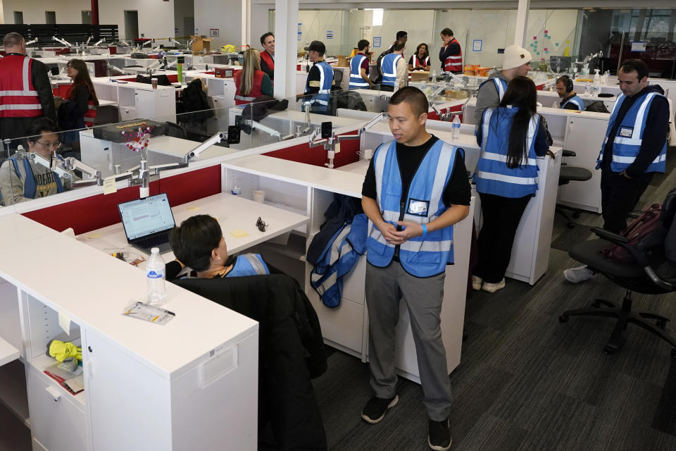 Researchers work in an office facility Thursday, Nov. 17, 2022, in Nashville, Tenn. By using artificial intelligence in a group of wirelessly connected cars, they were able to reduce the start-and-stop congestion on crowded roads that has no obvious cause. (AP Photo/Mark Humphrey)