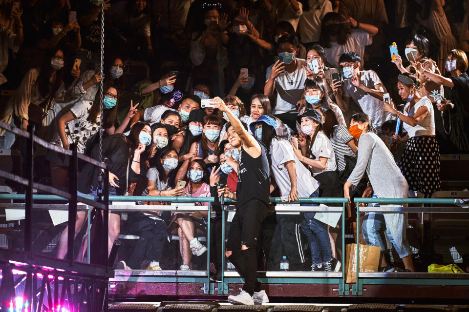 Chou interacts with the crowd, holding up an attendee's phone to capture a selfie<span class="copyright">An Rong Xu for TIME</span>