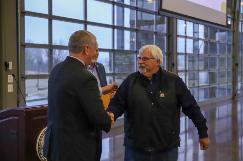 CDE Lightband employee Larry Waynic earns his 50-year pin, earlier this year, receiving it from Mayor Joe Pitts. The city is contemplating a 5% pay raise in the new budget to meet the challenges of a hiring crisis.